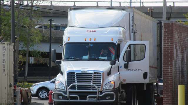 A Freightliner Cascadia pulling a McLane trailer along the highway
