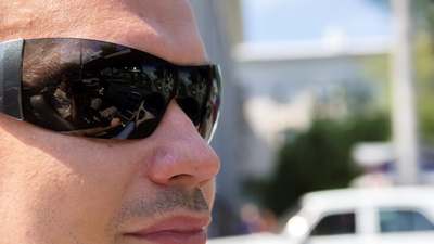 A driver wearing sunglasses in bright sun