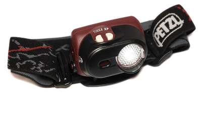 A Petzl Tikka XP headlamp with a red and black strap