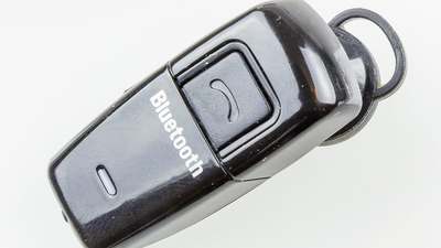 A small black mono Bluetooth headset with an ear hook